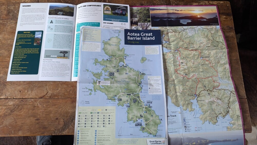 Photo d'une carte du trek Aotea de la Grande Barrière de Nouvelle-Zélande posée sur une table en bois