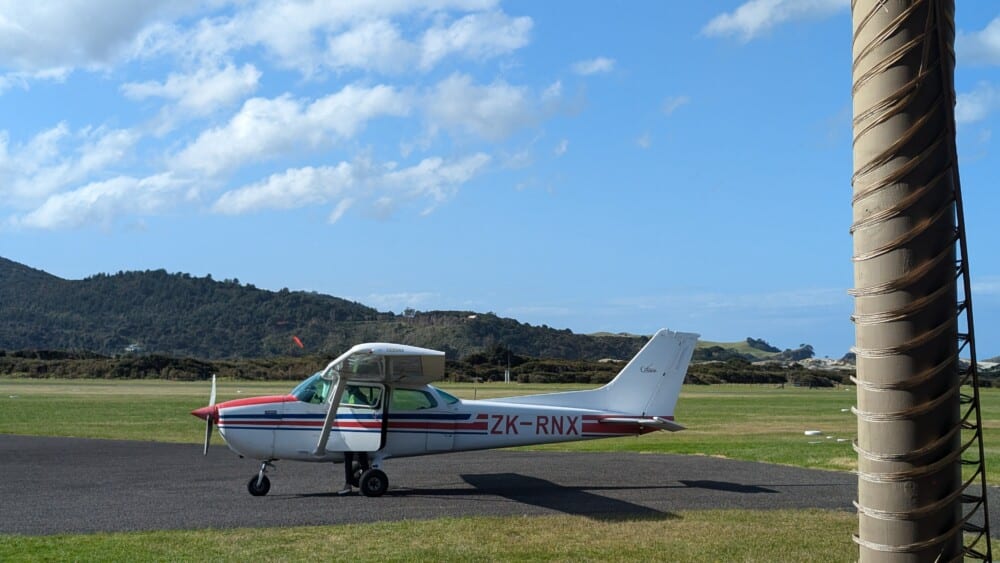 Photo d'un petit avion coucou prêt à décoller de l'île de la Grande Barrière vers Auckland