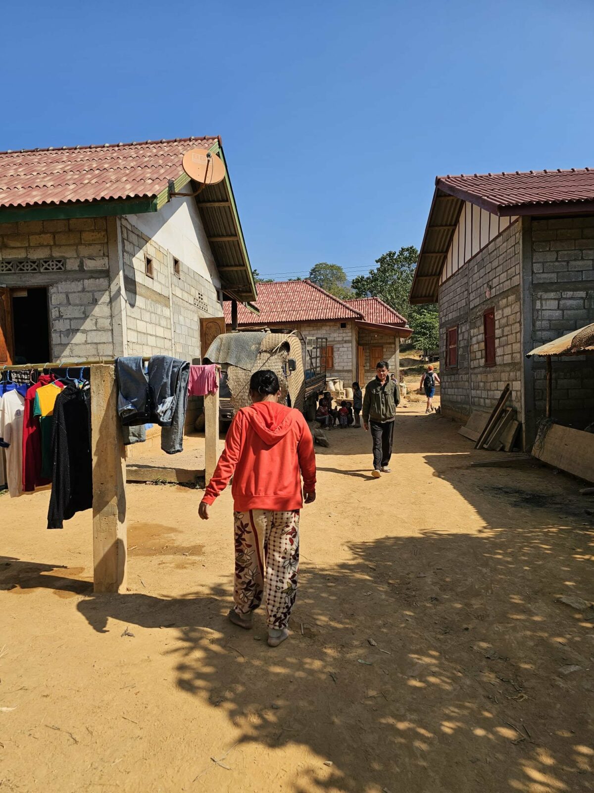 Femme habitante locale marchant sur un chemin en terre battue au milieu d’un village, lors des voyages de Fanny en Irlande et en Asie du Sud-Est. Illustration qui capture la vie quotidienne, l’authenticité et les paysages ruraux typiques