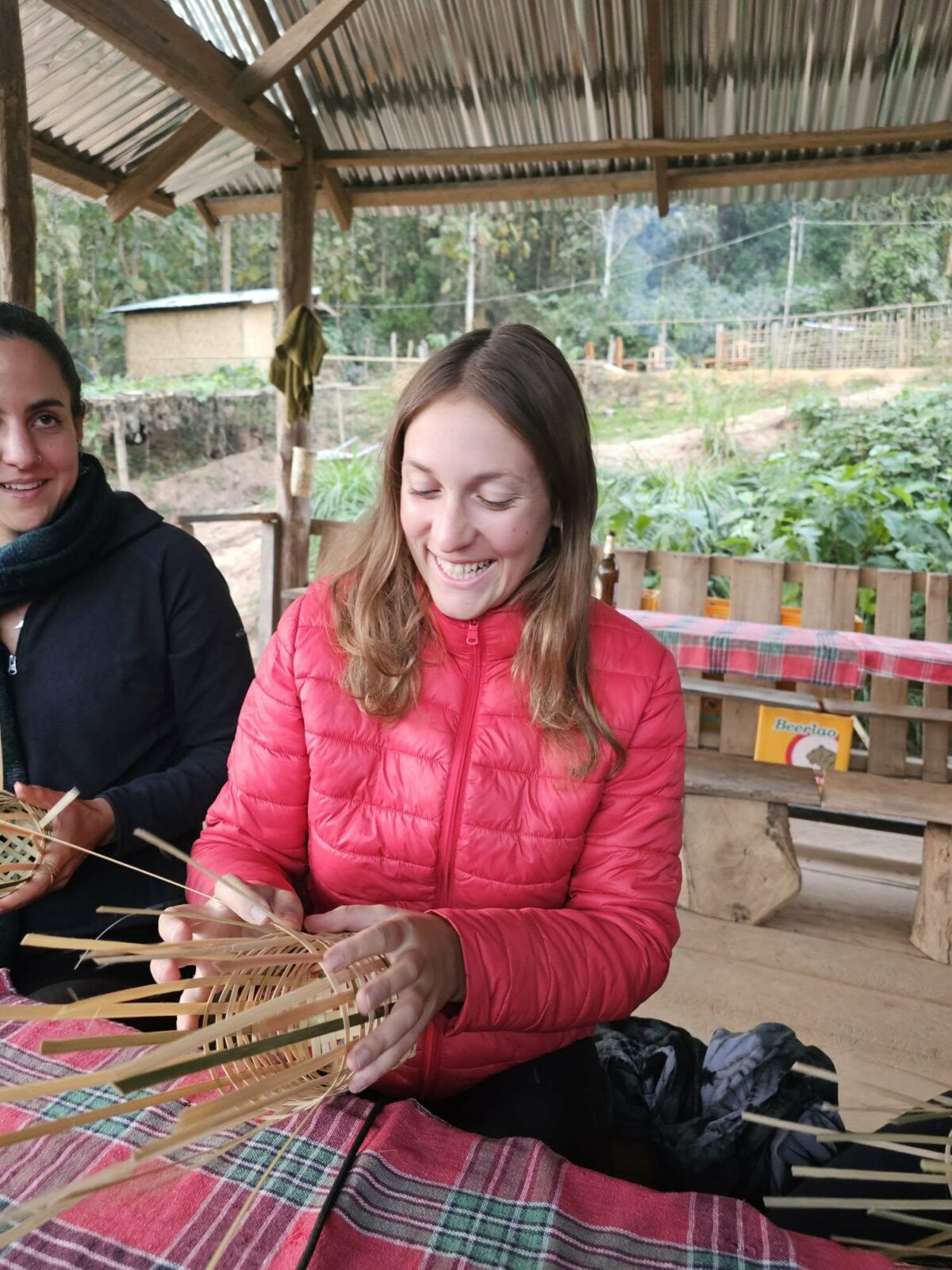 Fanny souriante façonne un objet en osier, découvrant l’artisanat local lors de ses voyages en Irlande et en Asie du Sud-Est. Illustration qui capture la créativité, l’apprentissage et la découverte culturelle