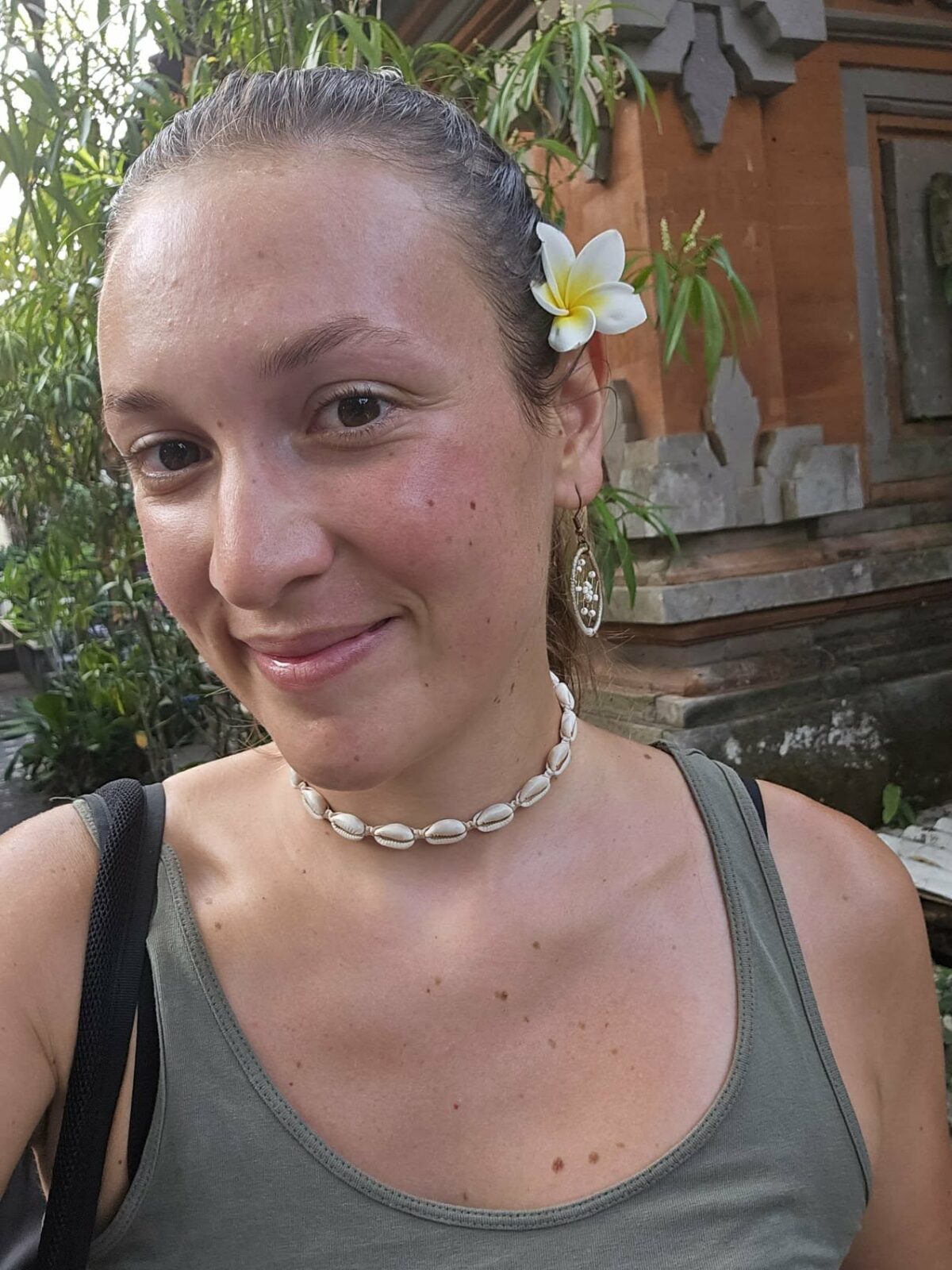 Portrait de Fanny souriante avec une fleur sur l’oreille, lors de ses voyages en Irlande et en Asie du Sud-Est. Illustration qui capture la douceur, la joie et le charme du voyage solo féminin