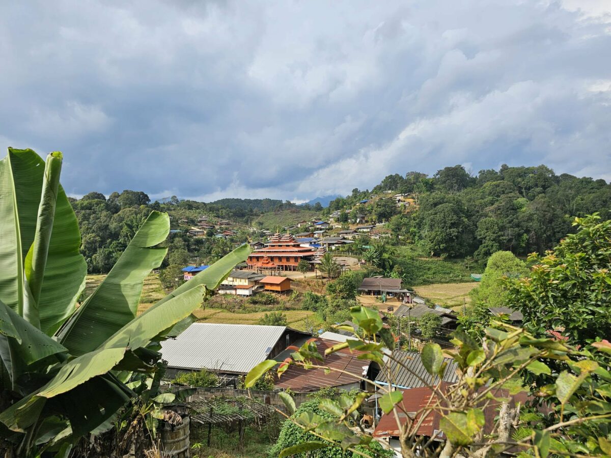 Temple surplombant une ville avec des bananiers au premier plan, lors des voyages de Fanny en Irlande et en Asie du Sud-Est. Illustration qui capture la beauté des panoramas, la culture locale et l’exploration des hauteurs