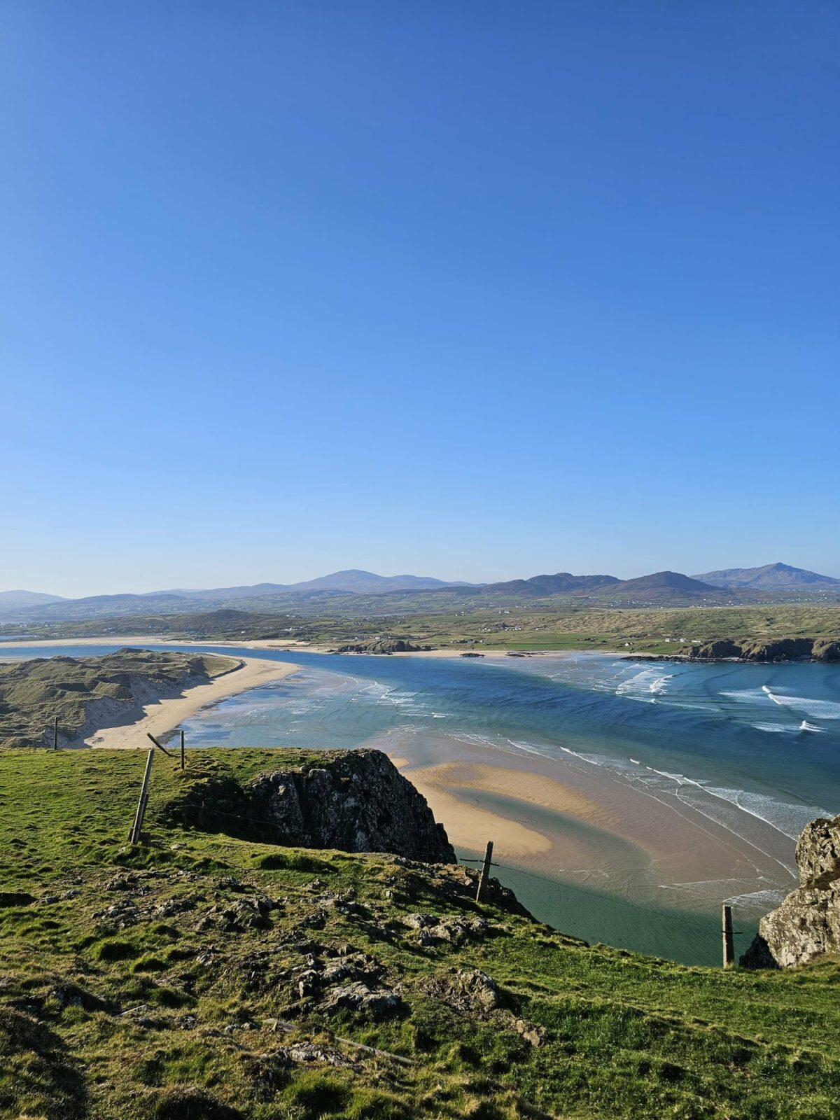 Panorama mêlant plage, eau et prairies verdoyantes, aperçu lors des voyages de Fanny en Irlande et en Asie du Sud-Est. Illustration qui capture la beauté naturelle, la sérénité et l’émerveillement des paysages explorés