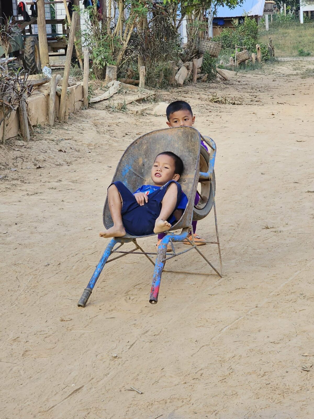 Deux enfants se poussent dans une brouette, observés par Fanny lors de ses voyages en Irlande et en Asie du Sud-Est. Illustration qui capture la joie, le jeu et la spontanéité des rencontres pendant le voyage solo
