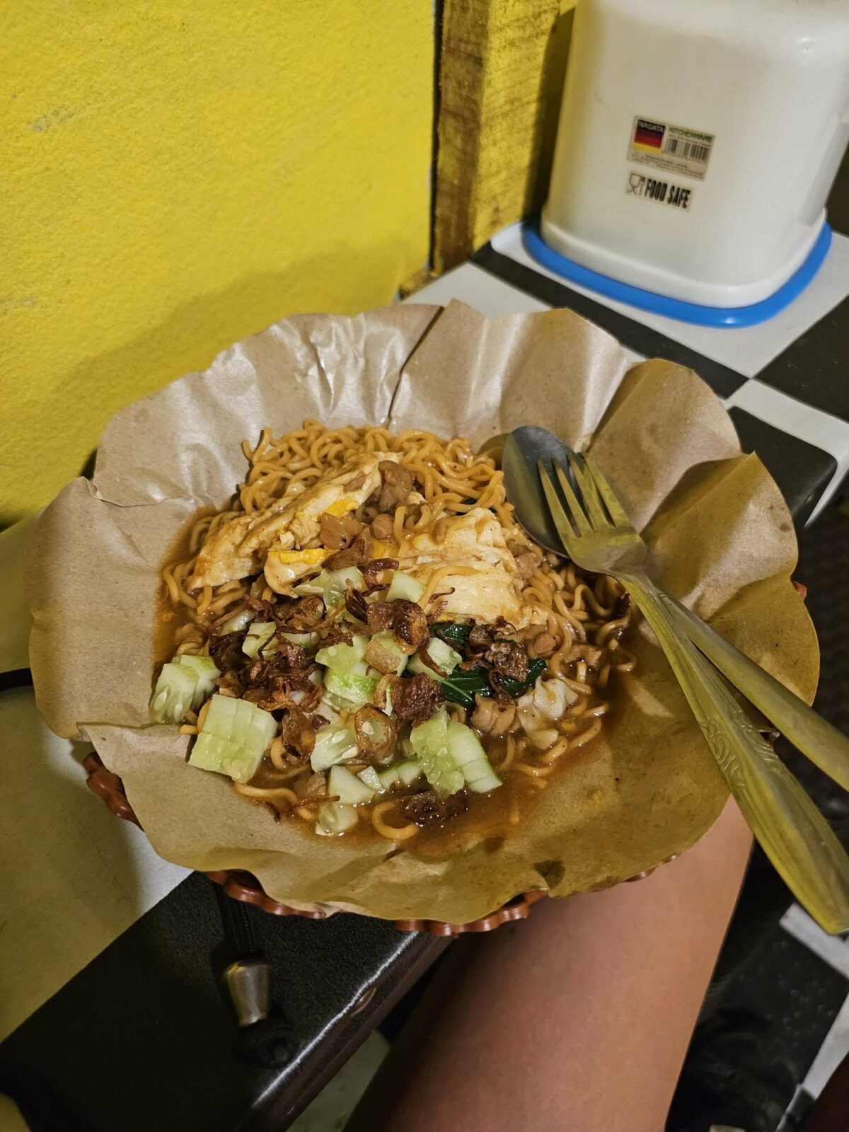 Fanny dégustant un plat de nouilles dans un emballage simple, lors de ses voyages en Irlande et en Asie du Sud-Est. Illustration qui évoque la découverte culinaire, la simplicité et l’authenticité du voyage solo