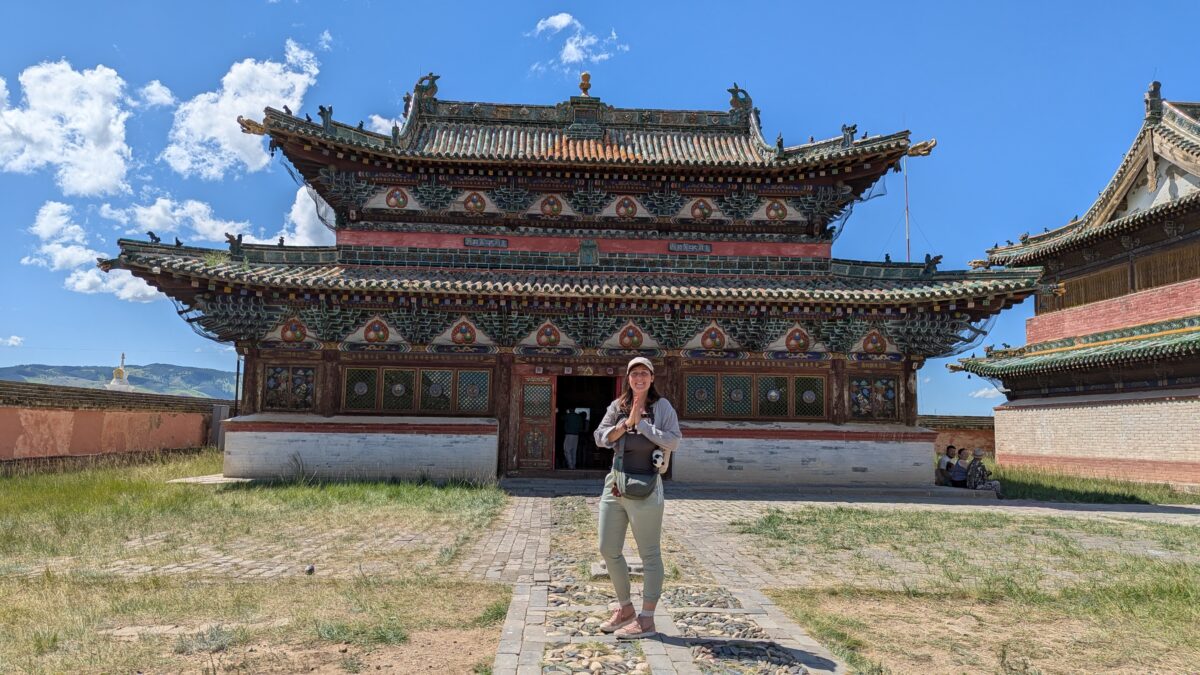 Inès en prière devant un monastère dans la région du Karakorum en Mongolie. Scène de recueillement face à un édifice religieux