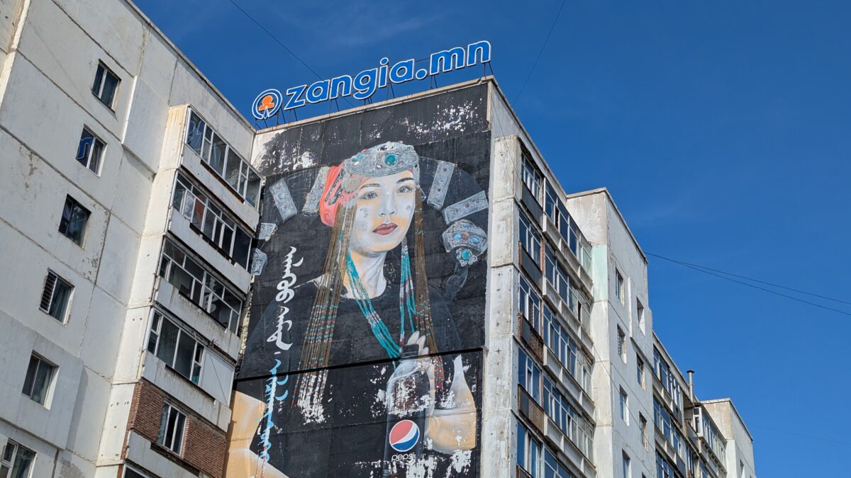 Jeune femme sur un bâtiment à Oulan-Bator en Mongolie, entourée de street art. Scène urbaine mêlant architecture et art de rue