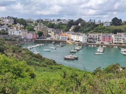 Paysage de Sauzon le long du GR340 à Belle-Île-en-Mer, France, avec des bateaux et des bâtiments colorés