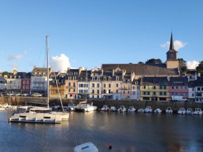 Paysage de Sauzon le long du GR340 à Belle-Île-en-Mer, France, avec des bateaux et des bâtiments colorés