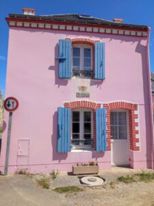 Maison typique de Belle-Ile-en-Mer avec volets bleus et façade rose