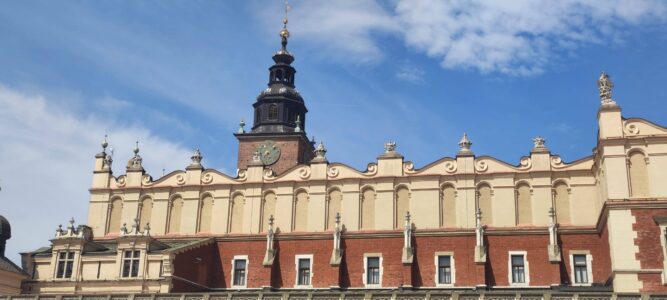 Vue de la place Rynek Główny à Cracovie, avec la halle aux Draps et l'animation des cafés et des passants