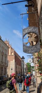 Rue à Cracovie avec une enseigne de dragon en arrière-plan, entourée d'architecture historique
