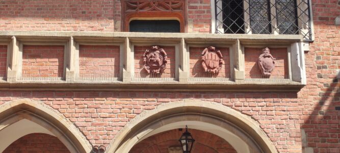 Façade du Collegium Maius à Cracovie, mettant en valeur le décor en brique rouge