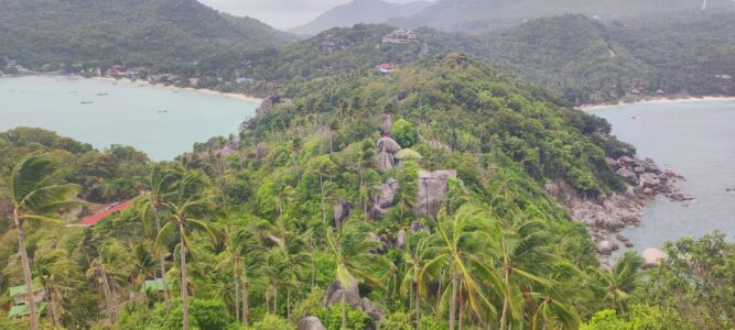 Photographie d'une baie entourée de montagnes et de forêts à Koh Tao