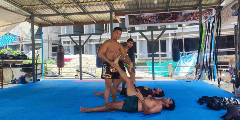 Un combattant de boxe effectue une prise sur un adversaire au sol à Koh Tao