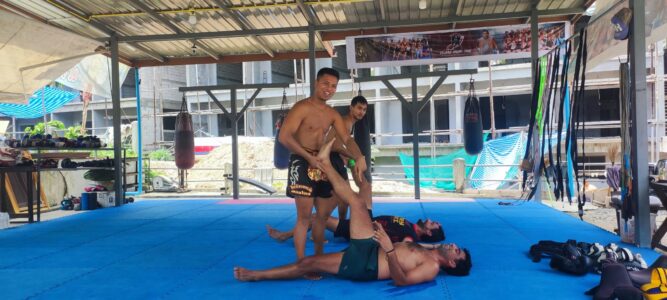 Un combattant de boxe effectue une prise sur un adversaire au sol à Koh Tao