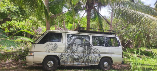 Van hippie coloré stationné à Koh Tao, entouré de palmiers