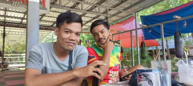 Deux boxeurs locaux souriants posant ensemble dans un camp de Muay Thai à Koh Tao, montrant camaraderie et passion pour le sport