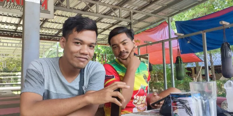Deux boxeurs locaux souriants posant ensemble dans un camp de Muay Thai à Koh Tao, montrant camaraderie et passion pour le sport
