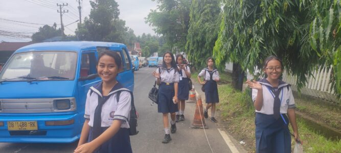 Photographie de cinq étudiantes souriantes à Manado, avec un bemo bleu garé à côté