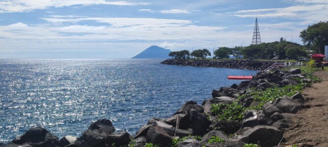 Photographie de la ville de Manado et de ses montagnes, prise le long de la jetée