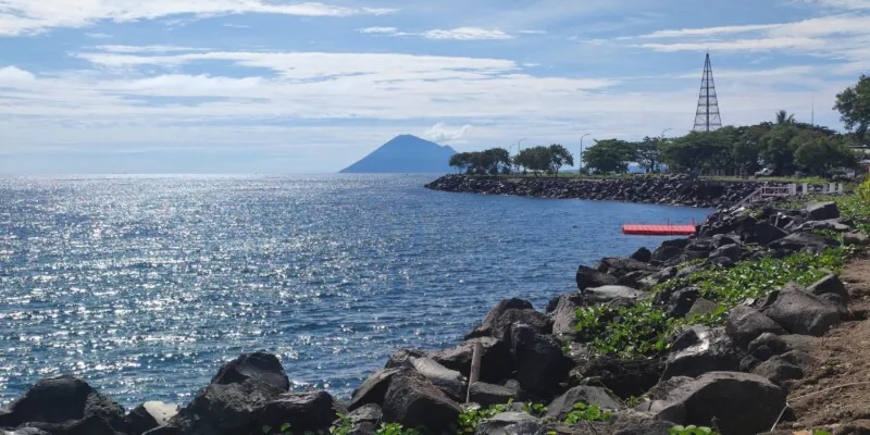 Photographie de la ville de Manado et de ses montagnes, prise le long de la jetée