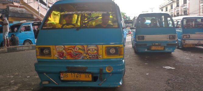 Photographie de bemos bleus à Manado, avec un design de street art et des conducteurs à l'intérieur