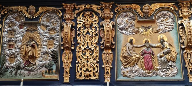 Zoom sur les motifs religieux du plafond bleu étoilé à l'intérieur de la Basilique Sainte-Marie à Cracovie, mettant en évidence des détails dorés