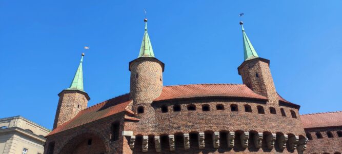 Barbacane Le Barbacane de Cracovie, une fortification médiévale, avec ses murs en briques rouges et ses tours, sous un ciel dégagé