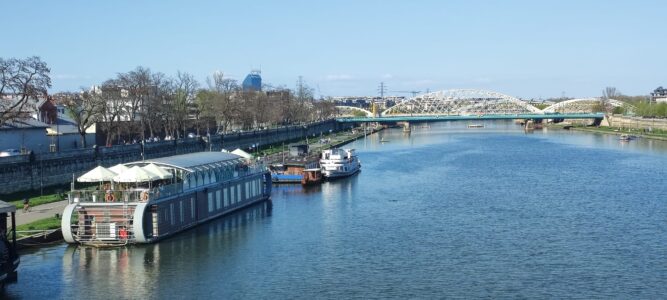Au bord de la Vistule Vue de la Vistule à Cracovie avec un pont et un bateau naviguant sur le fleuve