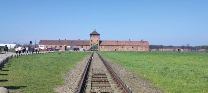 Une excursion difficile mais incontournable pour le devoir de mémoire Rails de train au site d'Auschwitz, avec la célèbre tour de garde en arrière-plan