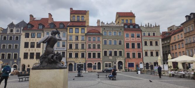 Photographie de la Vieille Ville de Varsovie avec la statue de la sirène au premier plan