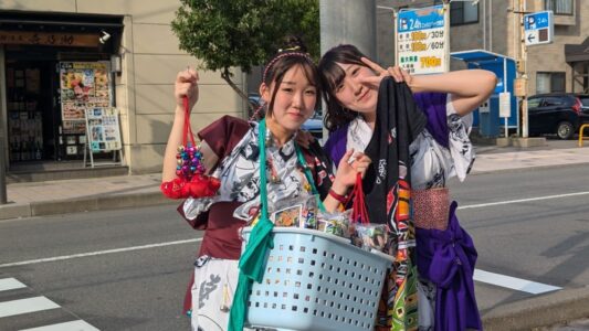 Deux jeunes femmes japonaises souriantes en costume traditionnel faisant signe de victoire