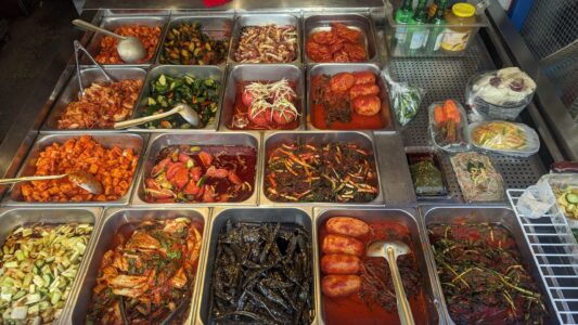 Plats coréens en sauce servis dans des inserts métalliques à Little Korea, Osaka