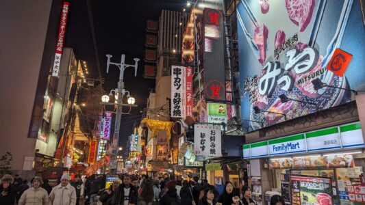Façade illuminée de Dotonbori à Osaka la nuit, avec des enseignes lumineuses et une ambiance festive