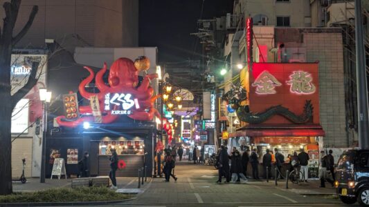 Rue animée de Dotonbori à Osaka avec des enseignes lumineuses et des restaurants japonais