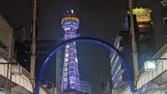 Tour Tsutenkaku illuminée en violet dans le quartier de Shinsekai à Osaka, Japon