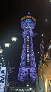 Tour Tsutenkaku illuminée en violet dans le quartier de Shinsekai à Osaka, Japon