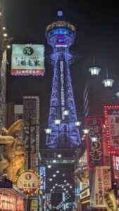 Tour Tsutenkaku illuminée en violet dans le quartier de Shinsekai à Osaka, Japon