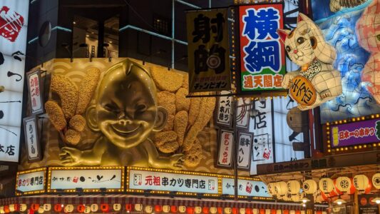 Façade vintage d’un restaurant dans le quartier de Shinsekai à Osaka avec des décorations de chats porte-bonheur