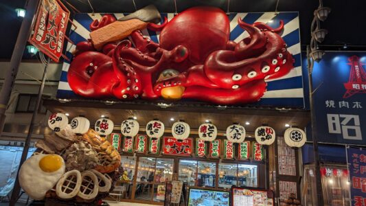 Façade vintage dans le quartier de Shinsekai à Osaka avec une enseigne en forme de poulpe géant