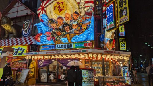 Façade vintage illuminée d'un restaurant dans le quartier de Shinsekai à Osaka, Japon, la nuit
