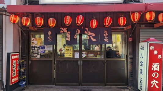 Rue de Shinsekai à Osaka ornée de lanternes colorées, créant une atmosphère chaleureuse et festive