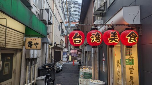 Lanternes colorées suspendues dans les rues de Shinsekai à Osaka, créant une ambiance festive et chaleureuse