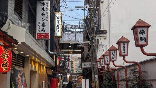Le temple se trouve au coeur du quartier de Dotonbori Enseignes lumineuses de Dotonbori avec un petit temple en arrière-plan