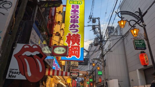 Enseigne de style pop art et lanterne colorée dans la rue animée de Dotonbori à Osaka
