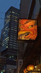 Affiche d'un dragon rouge dans un style néo-grunge, devant des bâtiments modernes d'Osaka