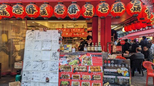 Lanternes colorées illuminant une rue animée de Shinsekai, célèbre pour sa street food à Osaka