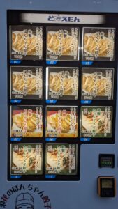 Distributeur de gyozas dans les rues d'Osaka Distributeur automatique de ramen à Osaka, proposant une variété de plats dans un cadre urbain animé