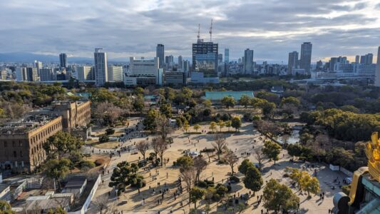 Vue depuis le château sur la ville d'Osaka Vue du château d'Osaka avec un parc verdoyant au premier plan et la ville en arrière-plan